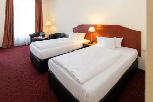 Una cama o camas en una habitación de Akzent Hotel Am Goldenen Strauss