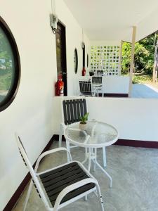 patio ze stołem i krzesłami w pokoju w obiekcie Coral Retreat Koh Yao Yai w mieście Ko Thanan