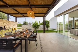an outdoor dining room with a table and chairs at Villa Trifilla - IsulaTravel in Modica