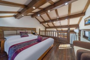 丽江Yingxue Inn Duplex Suite Loft的一间带床的卧室，位于带木质天花板的房间内