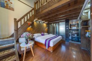 丽江Yingxue Inn Duplex Suite Loft的一间带大床和楼梯的卧室