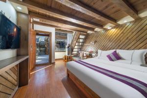 丽江Yingxue Inn Duplex Suite Loft的一间带一张大床和一台电视的卧室 更多7张照片