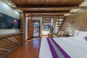 丽江Yingxue Inn Duplex Suite Loft的一间卧室，墙上有一张床和一台电视
