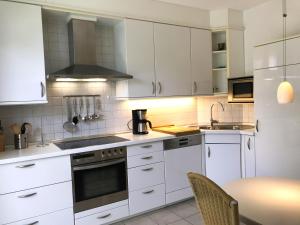 a kitchen with white cabinets and a stove top oven at Haus am Anker in Hüde