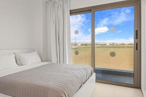 une chambre avec un lit et une grande fenêtre dans l'établissement Serenity Waves Villa 11, à Larnaka 13 autres photos