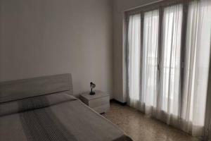 a bedroom with a bed and a window with curtains at Rivamare 3 Bilocale Fronte Mare in Marina dʼAndora