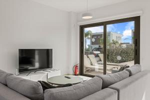 un salon avec un canapé et une télévision dans l'établissement Serenity Waves Villa 11, à Larnaka