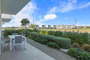 une terrasse avec une table, des chaises et un champ dans l'établissement Serenity Waves Villa 11, à Larnaka
