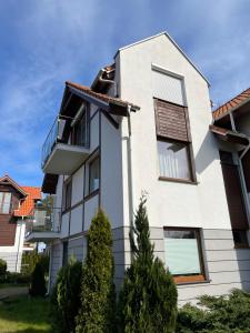 a white house with a red roof at Apartament Topolowa 2 in Dębki +2 photos