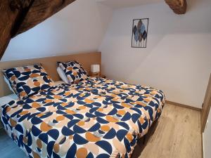 a bedroom with a bed with a blue and white comforter at Grand gîte du Moulin de Bourges in Momignies +17 photos