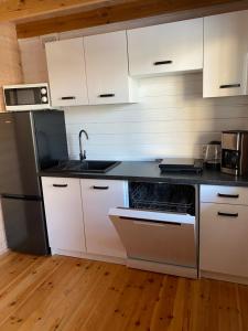 a kitchen with white cabinets and a sink at Rewalia in Rewal +54 photos