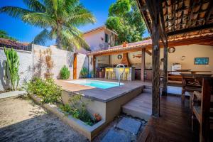 Un patio trasero con piscina y una casa. en Búzios Geribá 2 minutos a pé da praia, en Búzios