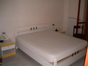 a white bed in a room with a table and a chair at Residence MILANO in Chieuti +21 photos
