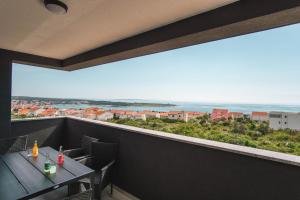 un balcone con tavoli e sedie e vista sull'oceano di Luna Deluxe a Novalja (Novaglia)