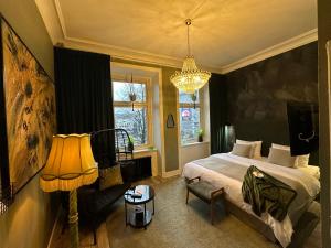una camera da letto con un letto e un lampadario di Hotell Onyxen, boutique- & lifestyle, Adults Only a Göteborg