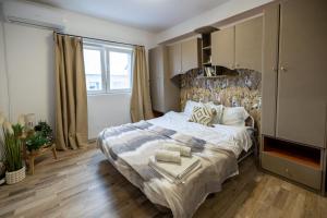 una camera da letto con un letto grande e una grande finestra di Cozy Studio Retreat - Quiet, Premium Stay a Timişoara