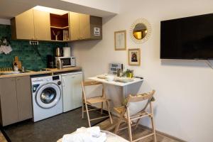 una cucina con lavatrice e tavolo con sedie di Cozy Studio Retreat - Quiet, Premium Stay a Timişoara