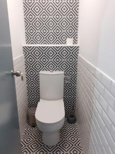 ein WC im Bad mit schwarzen und weißen Fliesen in der Unterkunft Appart 4 chambres Chez Vicky in Angoulême