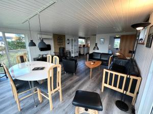 a living room and dining room with a table and chairs at Hyggeligt feriehus in Thisted