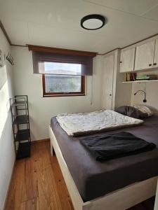 a bedroom with a bed in a tiny house at Vakantiehuis aan het Lauwersmeer in Anjum