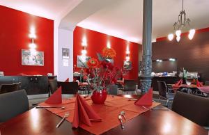 a dining room with a table and red walls at Hotel Garni Gästehaus der Kerckhoff-Klinik in Bad Nauheim