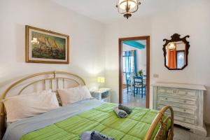 ein Schlafzimmer mit einem grünen Bett und einem Spiegel in der Unterkunft Villa Bella Vista in Imperia
