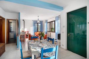 ein Esszimmer mit einem Tisch und einer grünen Tür in der Unterkunft Villa Bella Vista in Imperia