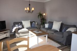 a living room with a couch and a table at Haus Carstensen-Bungalow 2 in Wyk auf Föhr