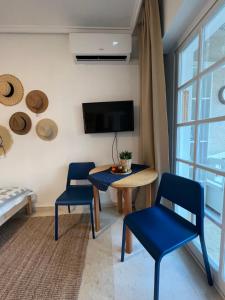 a living room with a table and chairs and a tv at Casa del Sombrero Los Locos beach in Torrevieja
