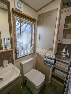 a bathroom with a white toilet and a sink at Lakeside Lodge - Jet Ski Lake in Tattershall