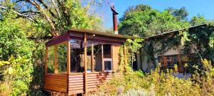 a small wooden house in the middle of a forest at Stanford Lake lodge in Haenertsburg
