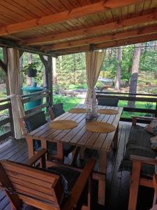 a wooden table and chairs on a porch at Domek pod sosnami in Grodziczno