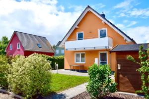 a house with a red and orange at Seeurlaub Müritz - Haus Nordlicht mit Sauna, Kamin, Wallbox, nur 250 m zum Strand in Röbel