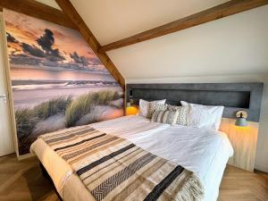 ein Schlafzimmer mit einem Bett und einem Gemälde an der Wand in der Unterkunft Zandbank Villa's in Vrouwenpolder