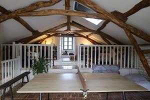 a dining room with a table in a room with wooden beams at Les Terrasses de La Serre in Lascabanes