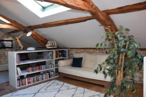 a living room with a white couch and a book shelf at Les Terrasses de La Serre in Lascabanes