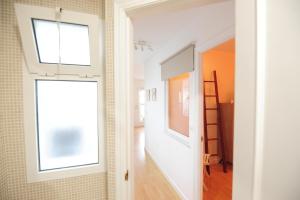 ein Zimmer mit einem Flur mit einem Fenster und einer Leiter in der Unterkunft Atico Brisa in Cádiz + 26 Fotos