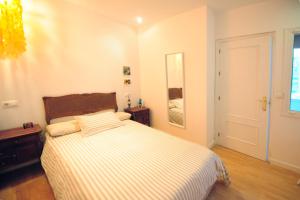 Schlafzimmer mit einem Bett mit gestreifter Decke in der Unterkunft Atico Brisa in Cádiz