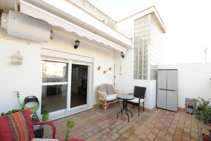 eine Terrasse mit Tisch und Stühlen an einem Gebäude in der Unterkunft Atico Brisa in Cádiz