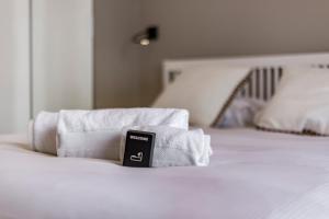 a pile of towels sitting on top of a bed at Le Chalet climatisé du 6ème in Lyon