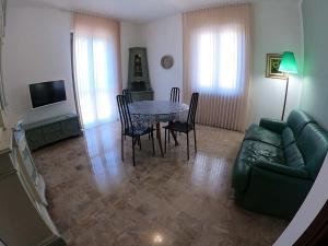 a living room with a green couch and a table at Apartment Superior 950 Meters From The Sea in Albisola Superiore