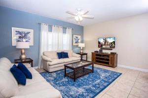a living room with a white couch and a tv at Five Bedrooms Home with Pool 4851 in Kissimmee