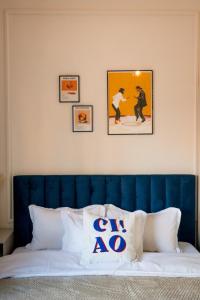 a bed with a blue headboard and three pictures on the wall at Decebal Modern Studio - Central Arad in Arad +18 photos