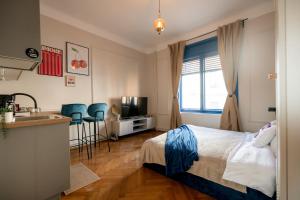 a bedroom with a bed and a kitchen and a sink at Decebal Modern Studio - Central Arad in Arad