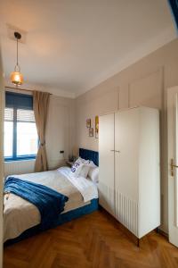a bedroom with a bed and a large white cabinet at Decebal Modern Studio - Central Arad in Arad