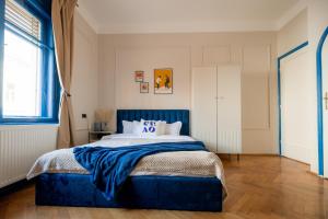 a bedroom with a blue bed with a blue headboard at Decebal Modern Studio - Central Arad in Arad