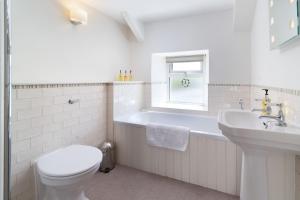ein weißes Badezimmer mit Toilette und Waschbecken in der Unterkunft Ford Hill Cottage in East Down + 20 Fotos