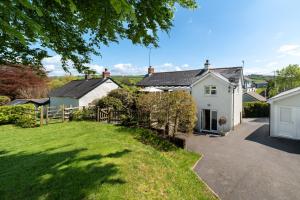 ein weißes Haus mit einem Zaun und einem Hof in der Unterkunft Ford Hill Cottage in East Down