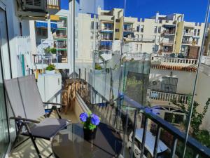 balkon ze szklanym stołem i krzesłami oraz budynkami w obiekcie Edf Albaida II 2D - Eurosur w mieście Nerja