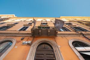 - un bâtiment avec un balcon et deux drapeaux dans l'établissement Appartamento Via XXIV Maggio, à Rome